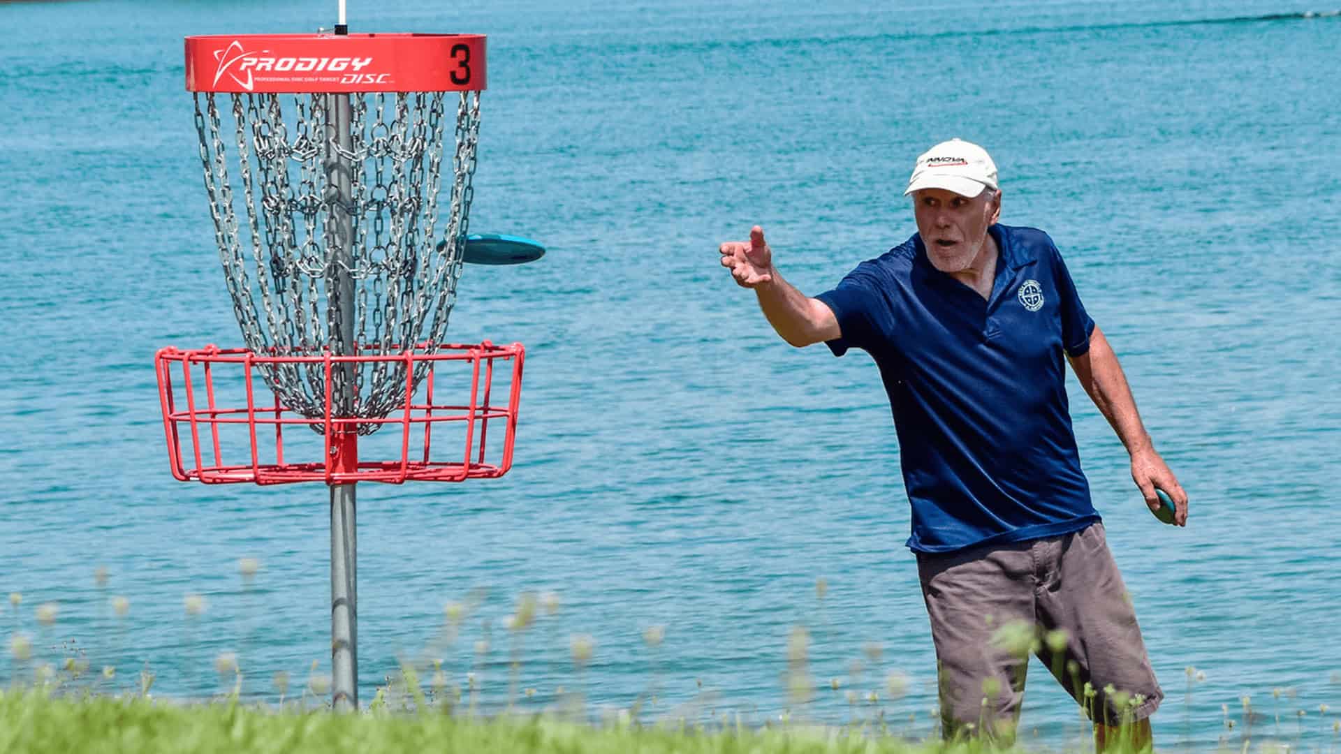Senior disc golf player throwing disc into a basket